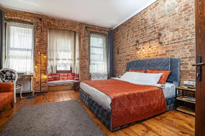 a bedroom with a bed and a brick wall at Stories Of Galata in Istanbul