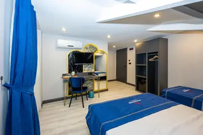 a bedroom with a bed and a desk with a blue blanket at İstanbul Paradise Hotel in Istanbul