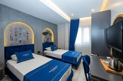 a hotel room with two beds and a flat screen tv at İstanbul Paradise Hotel in Istanbul