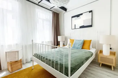 a white bedroom with a bed with orange and blue pillows at Stylish Modern Flat Steps from Istiklal in Istanbul