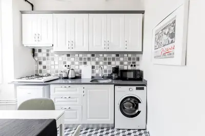 a kitchen with white cabinets and a washing machine at Stylish Modern Flat Steps from Istiklal in Istanbul