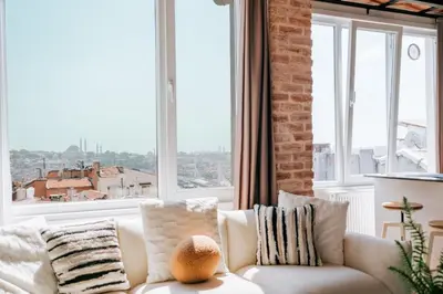 a white couch in a room with a large window at Stunning City View Luxury Flat by Galata Metro in Istanbul