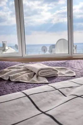 a blanket laying on a bed in front of a window at Hes Sultanahmet Tenedos in Istanbul