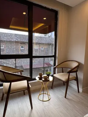 a room with two chairs and a table and a large window at Valenzasuites in Tuzla