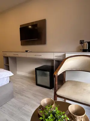 a living room with a tv and a table with a chair at Valenzasuites in Tuzla