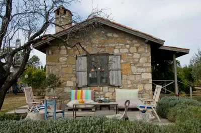 a stone house with a table and chairs in front of it at sakarya erenlerde köy konsepti doğal yaşam evi in Erenler