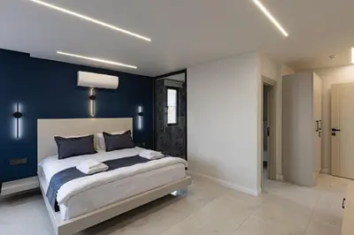 a bedroom with a large bed with blue walls at Safir Termal & Spa Otel in Çekirge İstasyonu