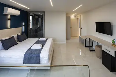 a bedroom with a bed and a desk and a tv at Safir Termal & Spa Otel in Çekirge İstasyonu