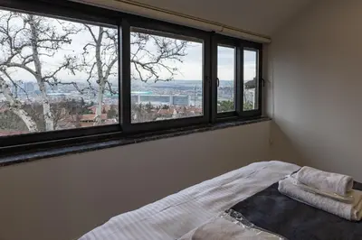 a bedroom with windows and a bed with a view at Safir Termal & Spa Otel in Çekirge İstasyonu