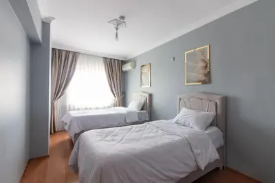 a bedroom with two beds and a window at Spacious & Modern 3BR Apartment Central Şişli in Istanbul