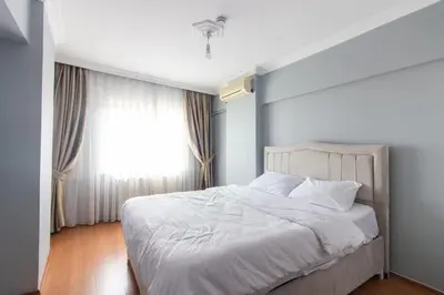 a bedroom with a white bed and a window at Spacious & Modern 3BR Apartment Central Şişli in Istanbul
