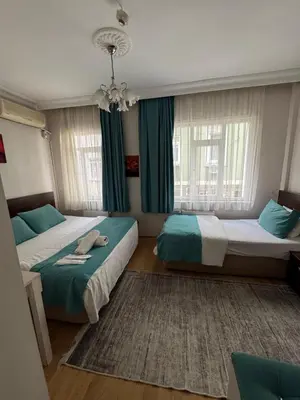a bedroom with two beds and a chandelier at BACHOS HOTEL SULTANAHMET sea view terrace in Istanbul