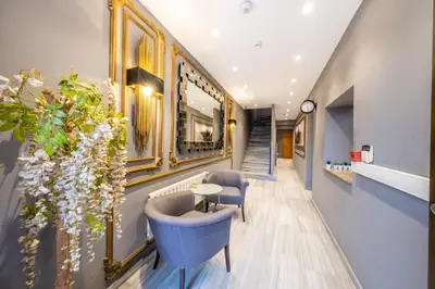 a hallway with chairs and a table and a clock at King Suite Hotel Beşiktaş in Istanbul