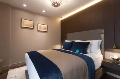 a bedroom with a large bed with blue and white pillows at Noble22 Suites-Special Category in Istanbul