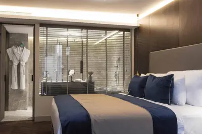 a bedroom with a large bed and a window with a dresser at Noble22 Suites-Special Category in Istanbul
