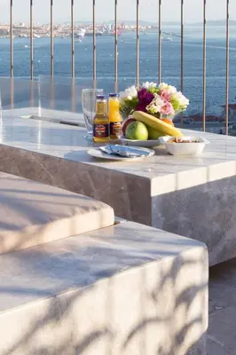 a table with a bowl of fruit and flowers on it at Noble22 Suites-Special Category in Istanbul