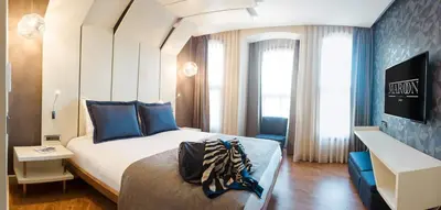 a bedroom with a large bed with blue pillows at Maroon Hotel Pera in Istanbul