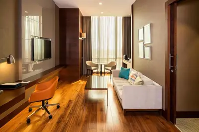 a living room with a couch and a table and chairs at Sheraton Grand Istanbul Atasehir in Istanbul