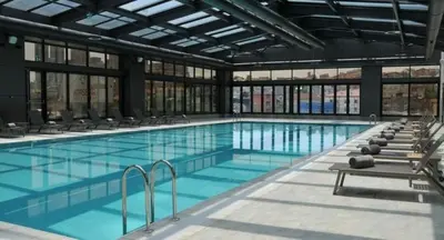 a large swimming pool with chairs in a building at Sheraton Grand Istanbul Atasehir in Istanbul