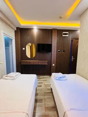 a hotel room with two beds and a tv at Liman Hotel in Istanbul