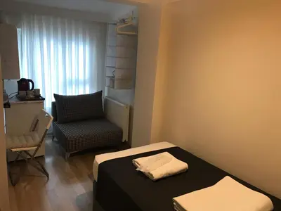 a small room with a bed and a chair at Goji's Apartments in Istanbul