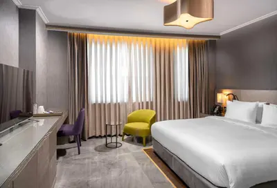 a hotel room with a bed and a yellow chair at Radisson Blu Hotel Istanbul Ottomare in Istanbul