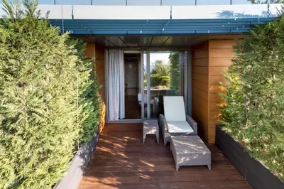 a patio with two chairs and a table between two bushes at Radisson Blu Hotel Istanbul Ottomare in Istanbul