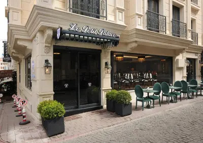 a restaurant with green chairs in front of a building at Le Petit Palace Hotel - Special Category in Istanbul