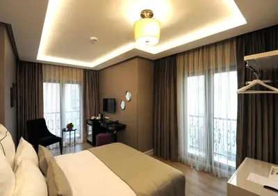 a hotel room with a large bed and windows at Le Petit Palace Hotel - Special Category in Istanbul