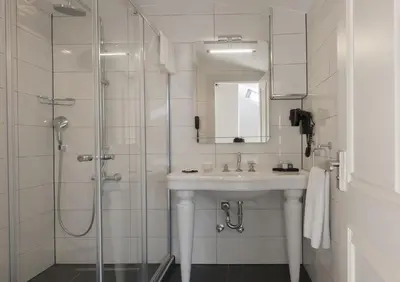 a white bathroom with a sink and a shower at Le Petit Palace Hotel - Special Category in Istanbul