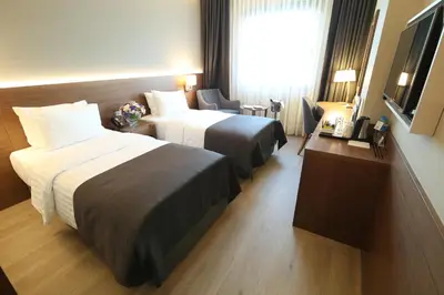 a hotel room with two beds and a window at Holiday Inn Bursa - City Centre by IHG in Bursa