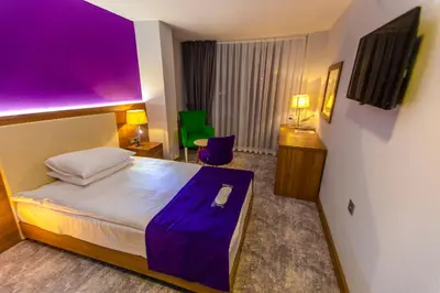 a hotel room with a bed with a purple ceiling at Business Palas Otel in Kocaeli