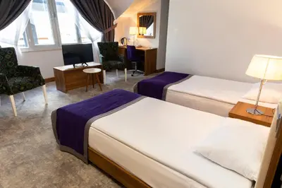 a hotel room with two beds and a desk at Business Palas Otel in Kocaeli