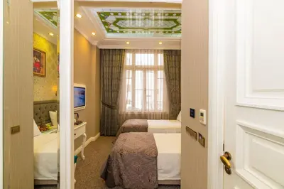 a hotel room with two beds and a window at Alpek Hotel in Istanbul