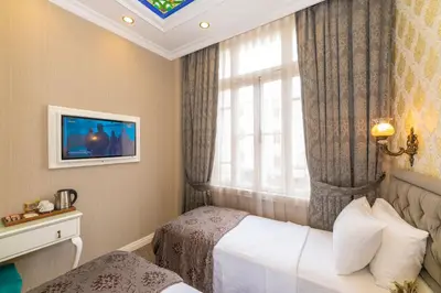 a hotel room with two beds and a window at Alpek Hotel in Istanbul
