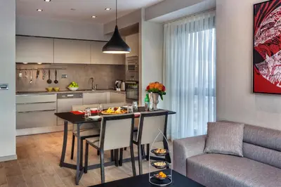 a kitchen and living room with a table and a couch at Fraser Place Antasya Istanbul in Istanbul