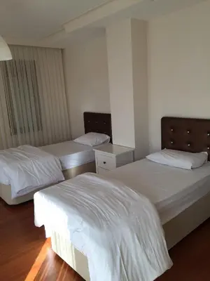 two beds in a room with white sheets at Villa Bursa in Bursa