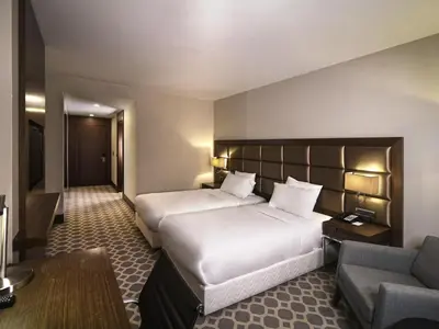 a hotel room with two beds and a couch at Mercure Istanbul West Hotel & Convention Center in Istanbul