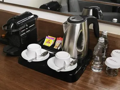 a coffee maker with cups and saucers on a counter at Mercure Istanbul West Hotel & Convention Center in Istanbul
