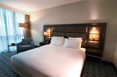 a hotel room with a large bed and a chair at Mercure Istanbul West Hotel & Convention Center in Istanbul