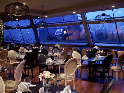 a restaurant with tables and chairs and a large window at Pullman Istanbul Hotel & Convention Center in Istanbul