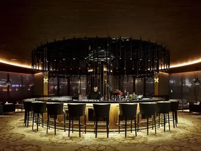 a bar with chairs and a person in a room at Pullman Istanbul Hotel & Convention Center in Istanbul