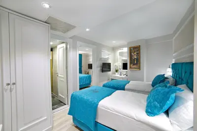a bedroom with two beds with blue sheets at Glamour Hotel Istanbul Sirkeci in Istanbul