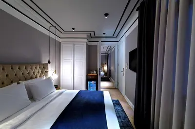 a bedroom with a large bed with a blue rug at Walton Hotels Galata in Istanbul