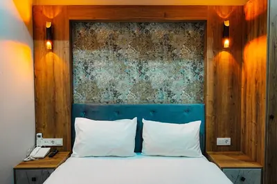 a bed with a blue headboard and white pillows at Reyyan Hotel in Istanbul