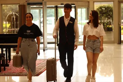 a group of three people walking down a hallway at ADM Grand Hotel in Istanbul