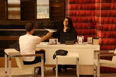 a man handing a woman a piece of paper at ADM Grand Hotel in Istanbul