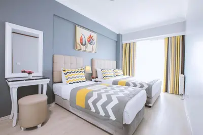 two beds in a bedroom with blue walls at Serenity Suites Istanbul Airport in Istanbul