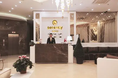 a man standing behind a counter in a lobby at Serenity Suites Istanbul Airport in Istanbul