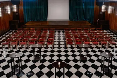 an empty auditorium with red chairs on a checkered floor at Soho House Istanbul in Istanbul